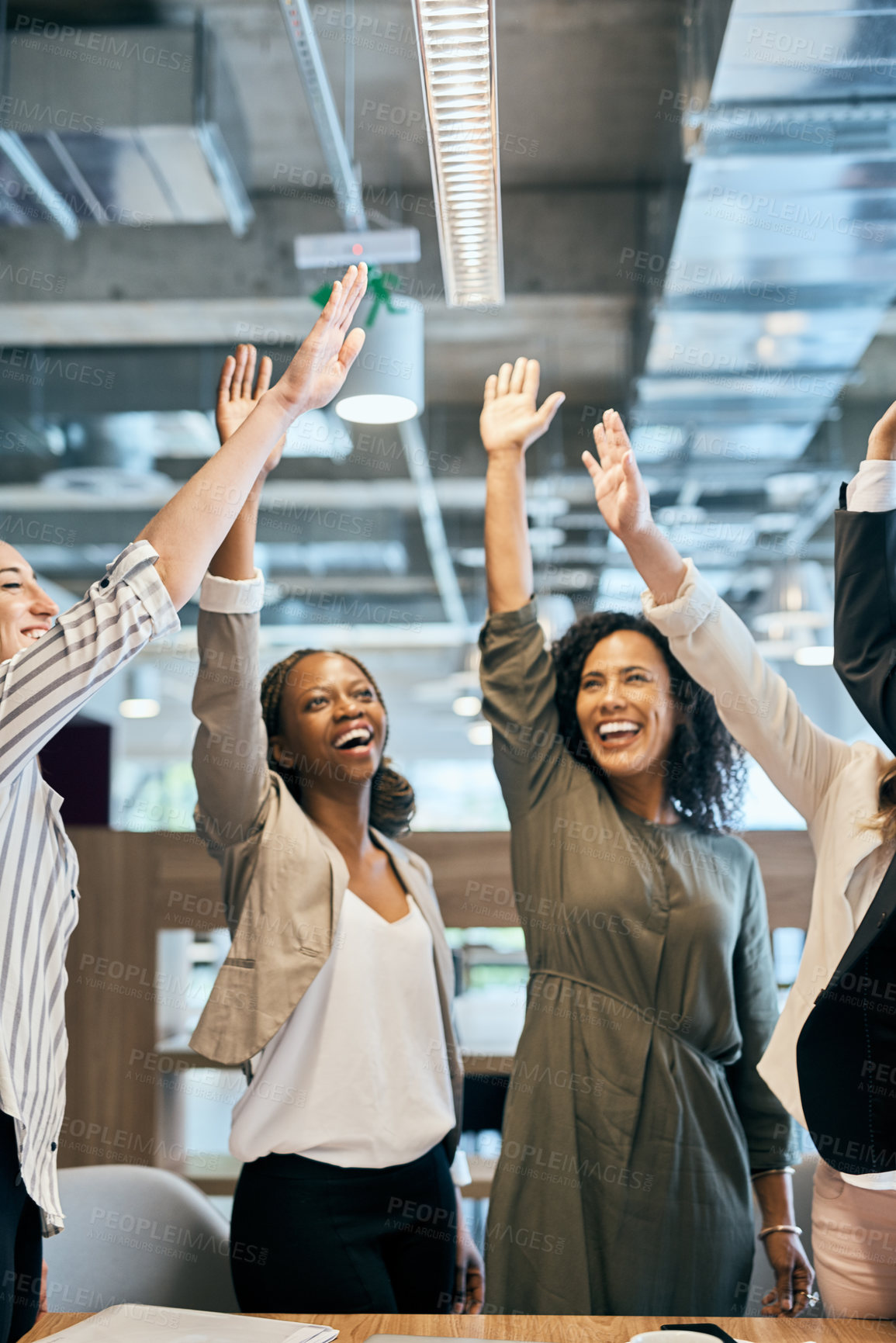 Buy stock photo Shot of a group of cheerful young businesspeople stretching out their hands for a high five after a meeting in the office at work