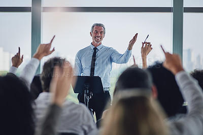 Buy stock photo Cropped shot of a handsome mature male speaker fielding questions during a seminar in the conference room