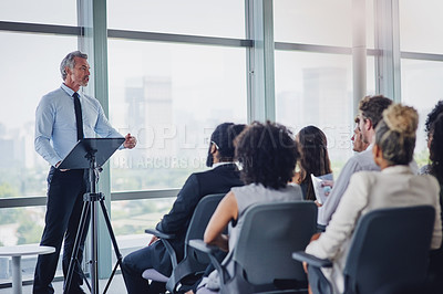 Buy stock photo Cropped shot of a handsome mature male speaker addressing a group of businesspeople during a seminar in the conference room