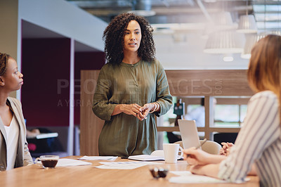 Buy stock photo Low angle shot of an attractive young businesswoman addressing her colleagues during a meeting in the boardroom