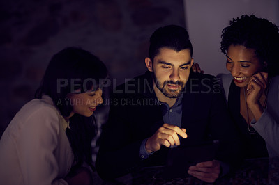 Buy stock photo Cropped shot of young businesspeople using a tablet together in the office