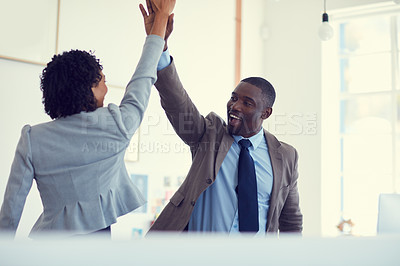 Buy stock photo Cropped shot of a young businessman and businesswoman giving each other a high five in the office