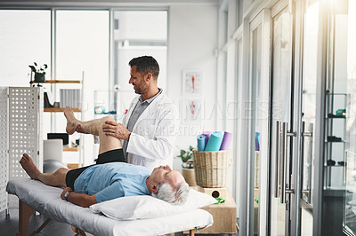 Buy stock photo Shot of a young male physiotherapist assisting a senior patient in recovery