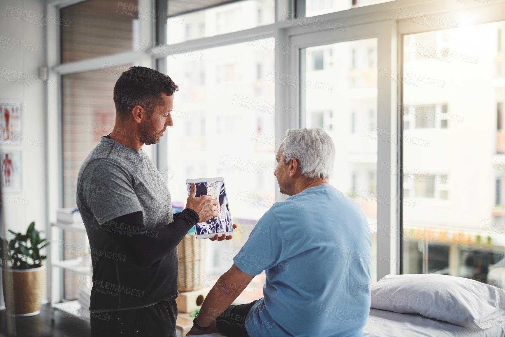 Buy stock photo Elderly, man and tablet in physio with Xray consultation for joint injury, healing and treatment planning. Rehab, senior person and chiropractor with digital technology for patient muscle health