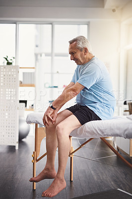 Buy stock photo Knee pain, leg and injury with old man in rehabilitation center for holistic healing, chiropractor and physiotherapy. Healthcare, muscle tension and accident with patient in physical therapy clinic