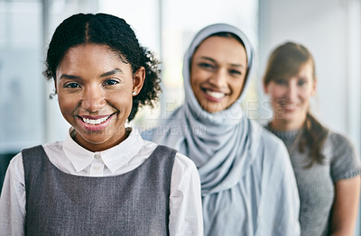 Buy stock photo Portrait of a group of young confident businesswomen standing in a row behind each other inside of the office during the day