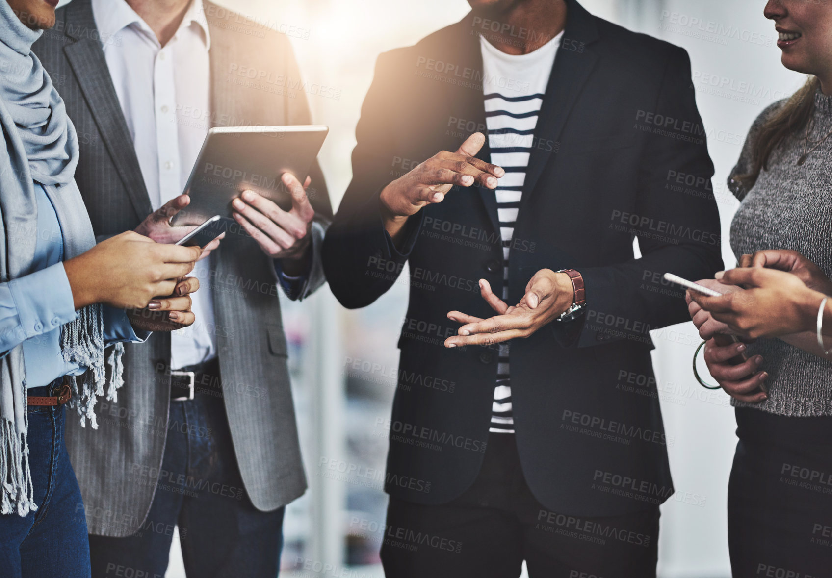 Buy stock photo Shot of a group of unrecognizable businesspeople having a discussion in the office at work during the day