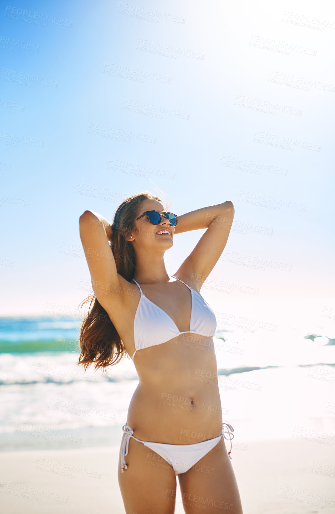 Buy stock photo Shot of a beautiful young woman enjoying the day at the beach
