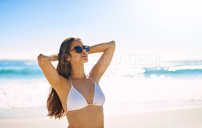 Buy stock photo Shot of a beautiful young woman enjoying the day at the beach