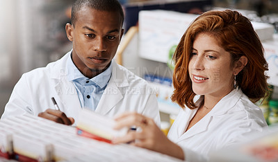 Buy stock photo Shot of two pharmacists working together in a chemist