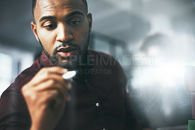Buy stock photo Shot of a young businessman brainstorming in a modern office