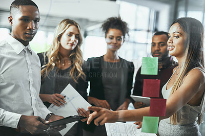 Buy stock photo Shot of a group of young businesspeople brainstorming in a modern office