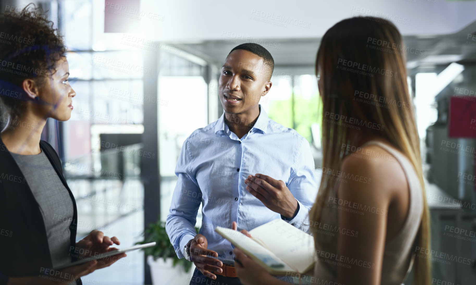 Buy stock photo Shot of a group of young businesspeople having discussion in a modern office