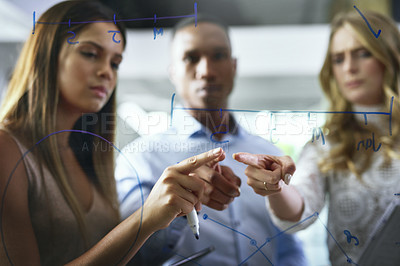 Buy stock photo Shot of a group of young businesspeople brainstorming in a modern office