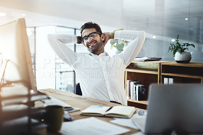Buy stock photo Shot of a young businessman taking a break while working in an office