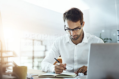 Buy stock photo Shot of a young businessman working in an office