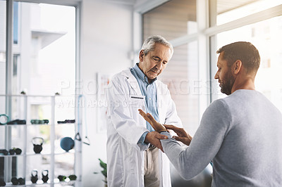 Buy stock photo Cropped shot of a senior doctor giving his male patient a thorough checkup during his consultation