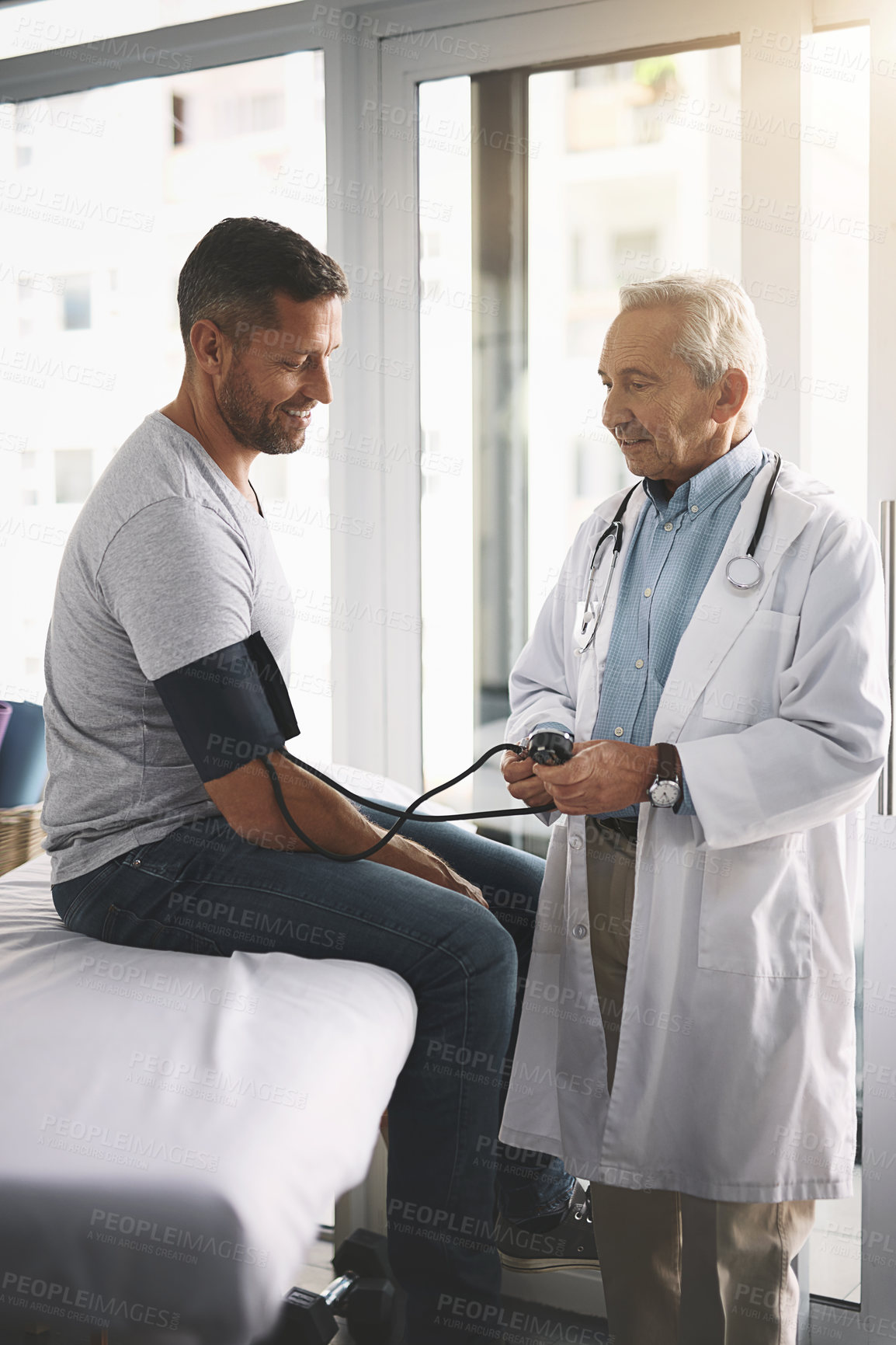 Buy stock photo Healthcare, man and doctor in consultation for blood pressure test, checkup and assessment in clinic. Advice, patient and medical professional in office for hypertension, diabetes or health insurance