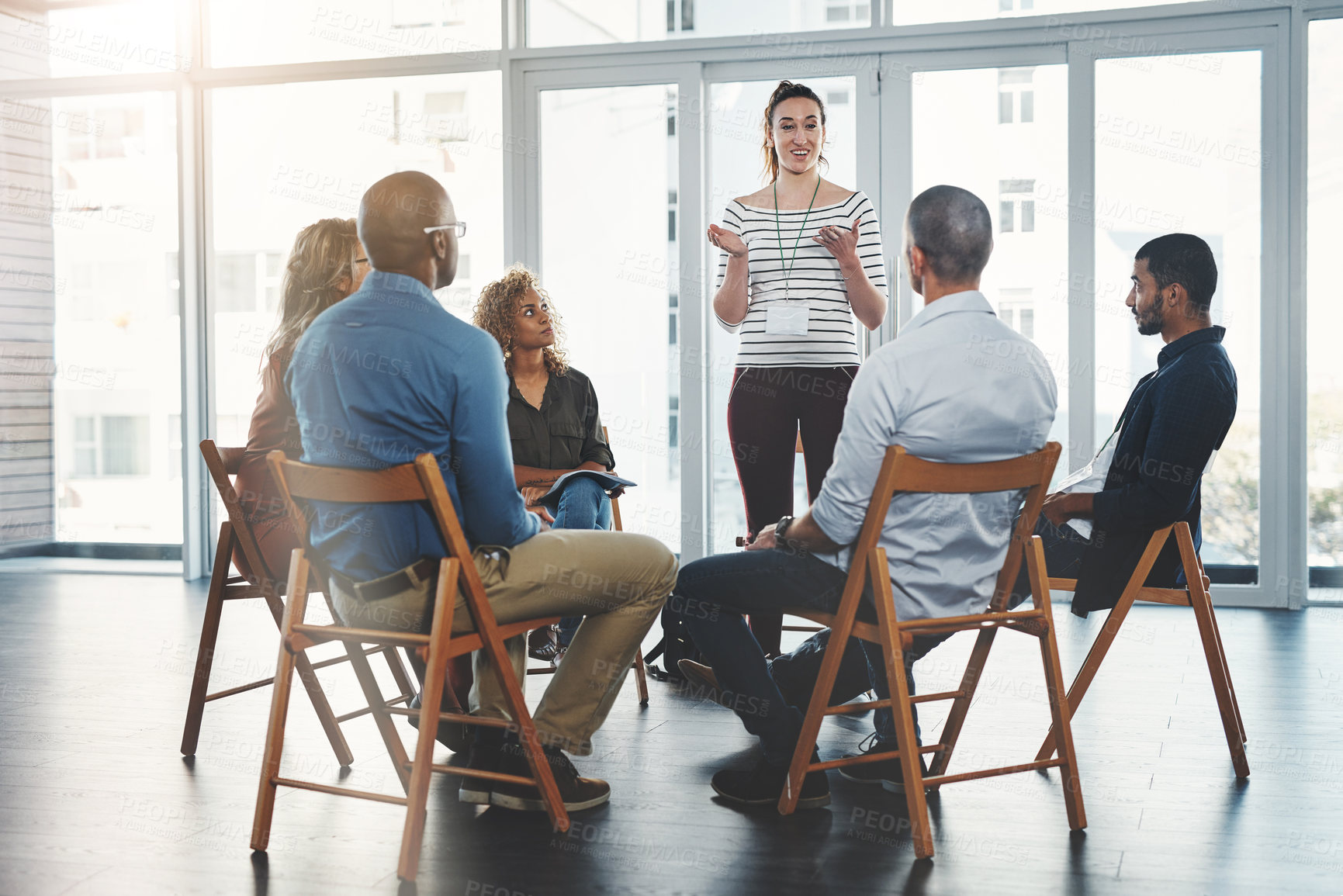 Buy stock photo Group of diverse creative design business people, sitting in an innovation team growth meeting together. Modern casual employees listening to manager about support and unity in the workplace 