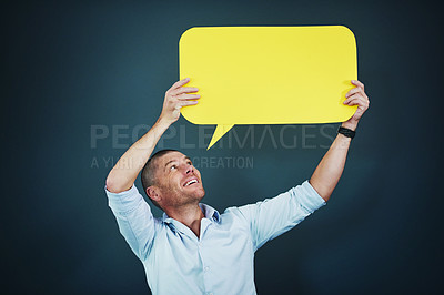 Buy stock photo Studio shot of a man holding a speech bubble against a blue background