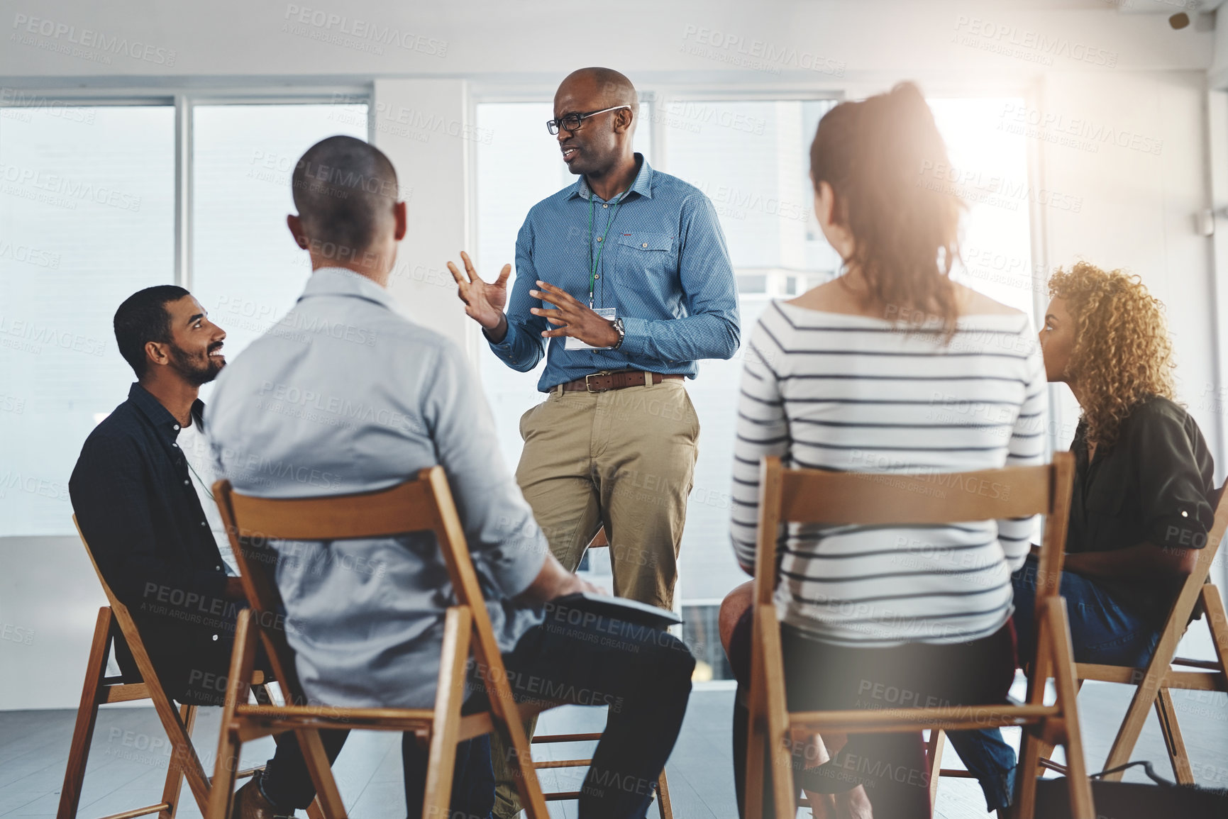 Buy stock photo Leader, manager or boss talking to and teaching his team of employees and colleagues in a meeting, seminar or workshop at the office. Male CEO planning, discussing strategy and coaching staff at work