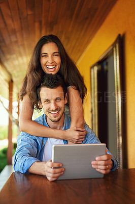Buy stock photo Portrait of a young couple using a digital tablet together outdoors