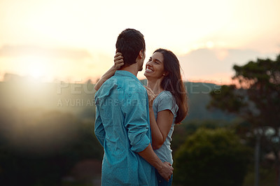 Buy stock photo Cropped shot of an affectionate young couple sharing a loving moment while standing outdoors