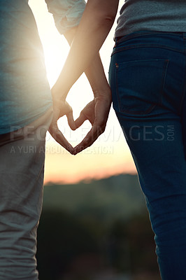 Buy stock photo Support, heart hands and closeup with couple in nature for love, bonding and honeymoon vacation. Relax, care and adventure with people and emoji sign on date for holiday, sunset and romance together