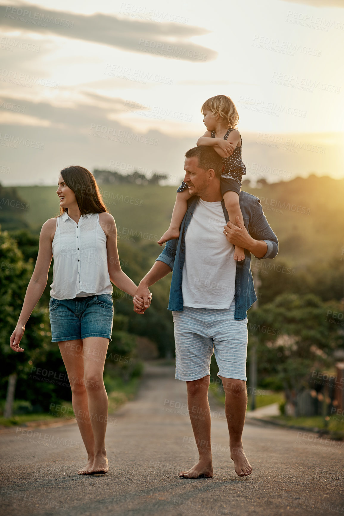 Buy stock photo Holding hands, walking and child with parents in nature for family adventure together on vacation. Happy, bonding and kid on shoulders of father with mother outdoor in field for countryside holiday.