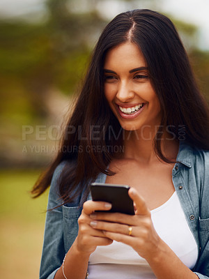 Buy stock photo Shot of an attractive young woman using a mobile phone in a park