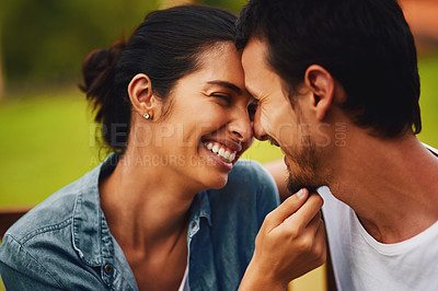 Buy stock photo Shot of an affectionate young couple spending a romantic day in the park