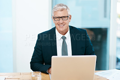 Buy stock photo Cropped portrait of a handsome mature businessman working on his laptop in the office