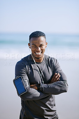 Buy stock photo Portrait of a sporty young man listening to music while exercising outdoors