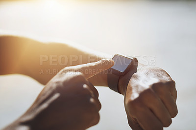 Buy stock photo Closeup shot of an unrecognizable man checking his smartwatch while exercising outdoors