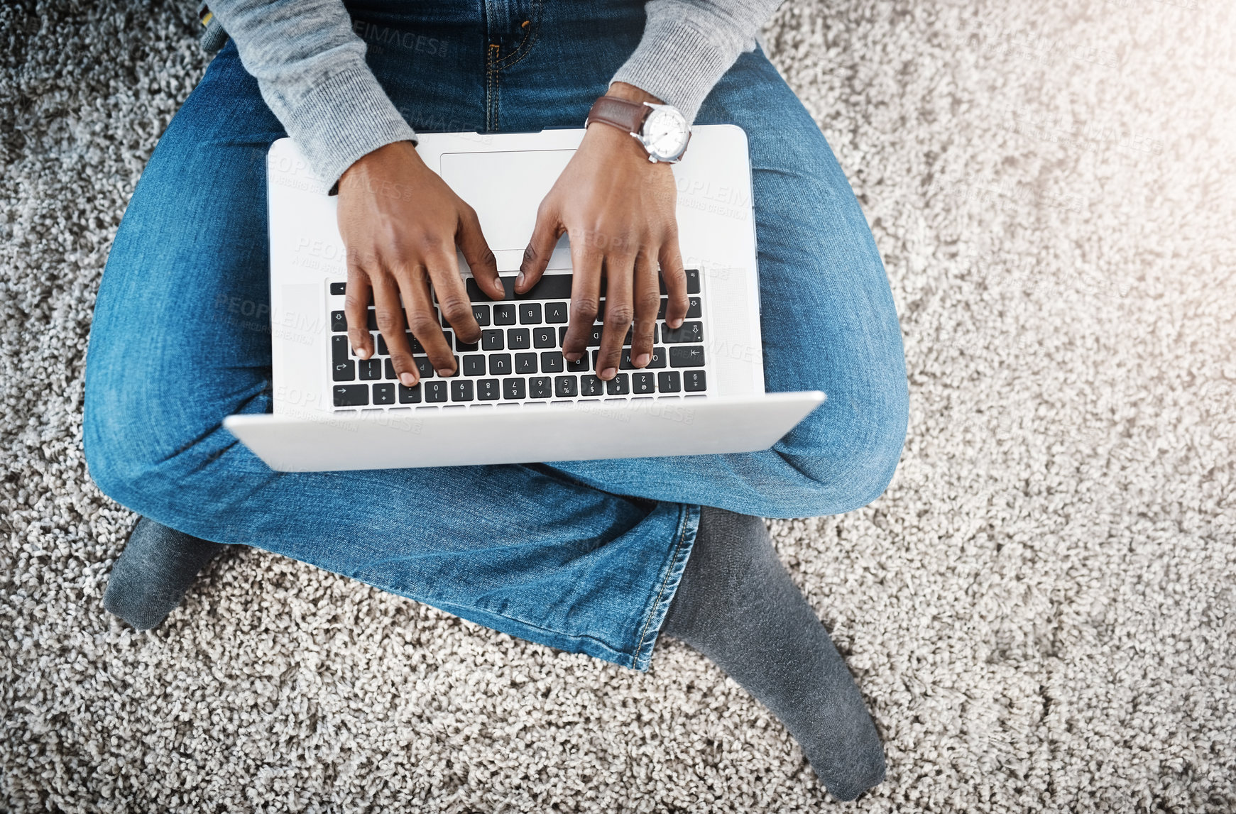 Buy stock photo Shot of a happy young man using a laptop while relaxing at home