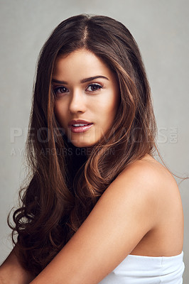 Buy stock photo Studio shot of a young beautiful woman with long gorgeous hair posing against a grey background