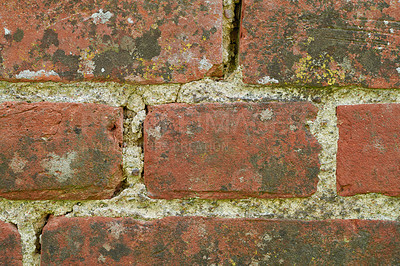 Buy stock photo Closeup of a dirty red brick wall with copy space. Weathered exterior surface of a house. Rough surface texture of building blocks with concrete cement layers for construction of a solid structure. 