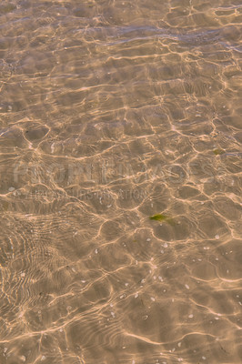 Buy stock photo Clear beach water on a summer day with copy space. Above view of calm low tide sea ripples during spring. Closeup of the bright sun reflection shining off the shallow ocean useful as a background