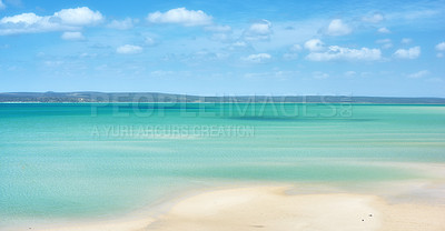 Buy stock photo Beautiful beach landscape and horizon under cloudy blue sky copy space with calm and tranquil ocean scenery. A sea with a mountain in the background. A quiet coastal holiday or vacation by the shore