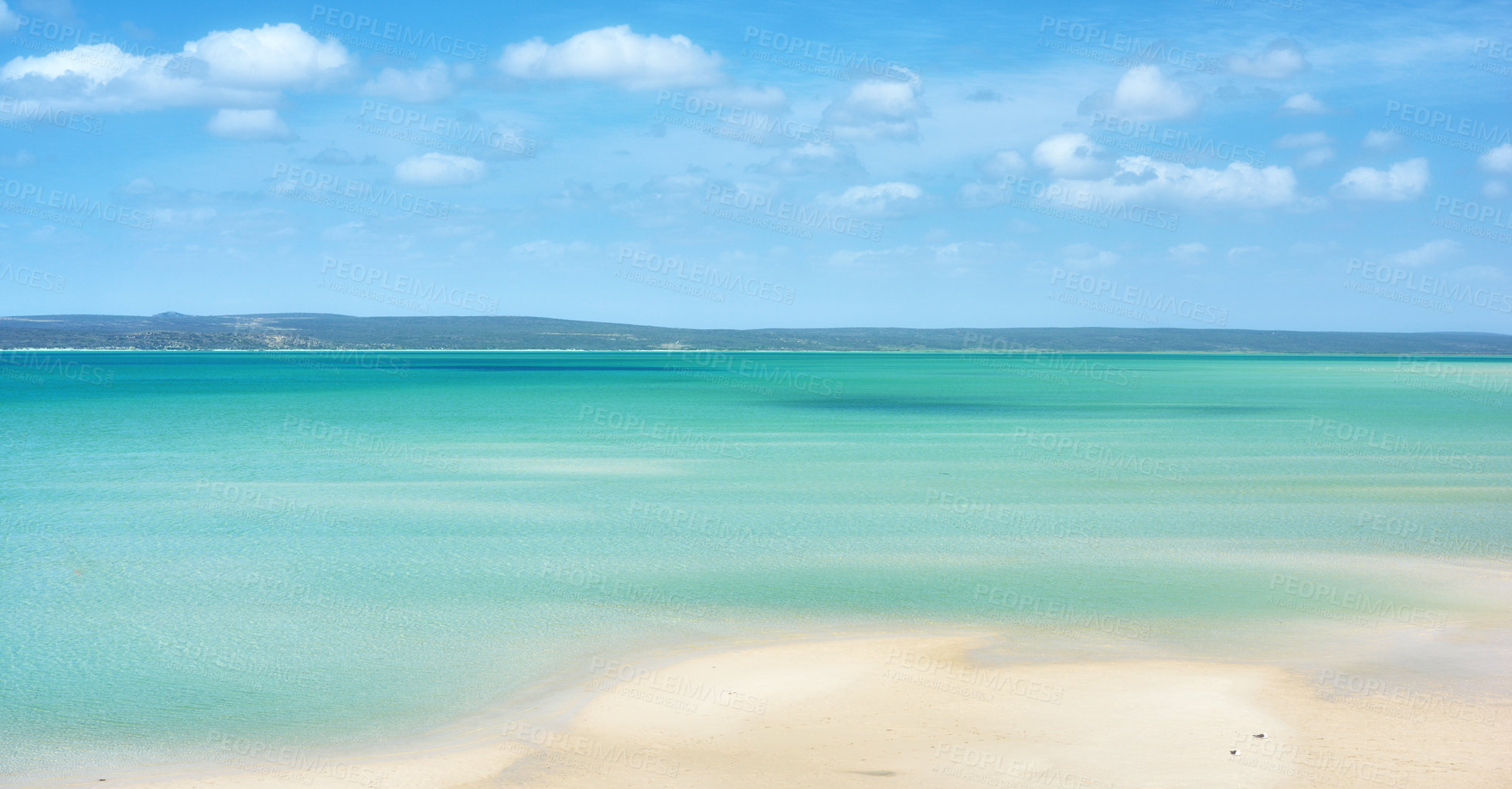 Buy stock photo Beautiful beach landscape and horizon under cloudy blue sky copy space with calm and tranquil ocean scenery. A sea with a mountain in the background. A quiet coastal holiday or vacation by the shore