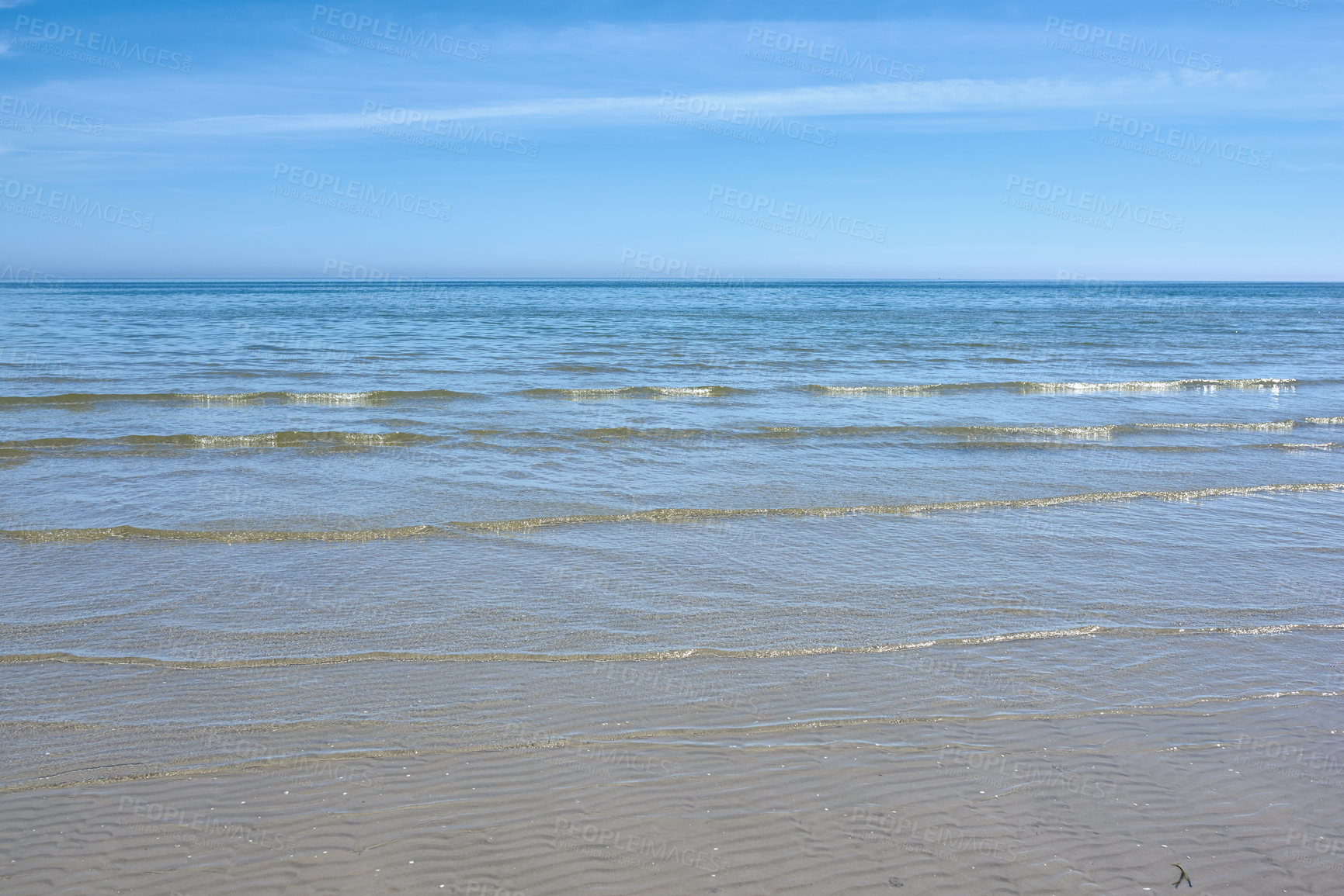 Buy stock photo Small ocean waves on the shore against a clear blue sky with copy space. Landscape of the wide open sea or beach with calm water on a bright sunny day. Sea surface with ripples on the horizon