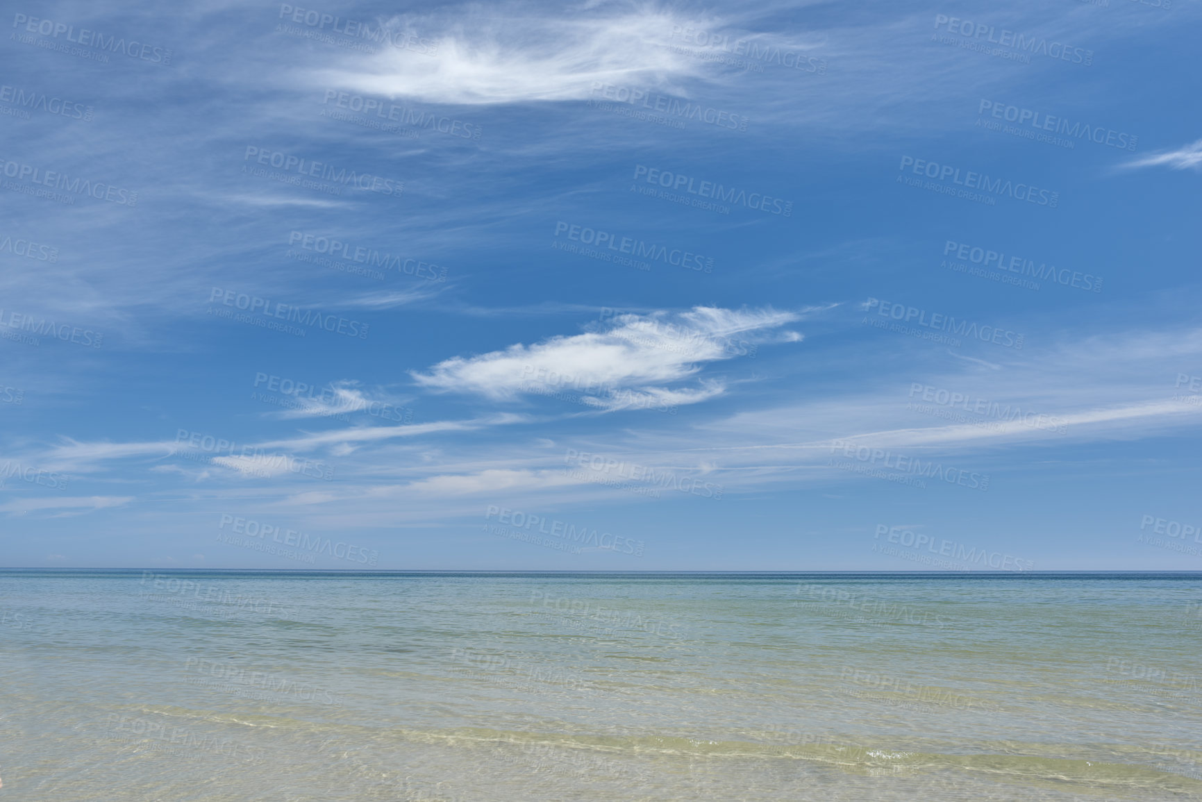 Buy stock photo Copyspace at the beach with a cloudy blue sky background above the horizon. Calm ocean waves across an empty sea along the coast. Peaceful and tranquil landscape for a relaxing and zen summer getaway