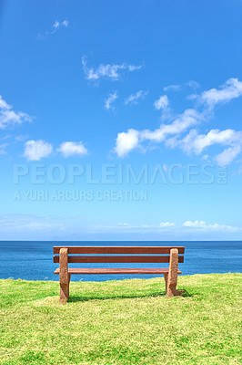 Buy stock photo Beautiful beach view from a bench with copy space on a summer day with a blue sky background. Peaceful and calm seascape with a seat in a coastal vacation location. Scenic land of sea or ocean shore