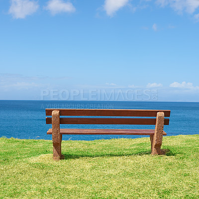 Buy stock photo Empty bench overlooking the ocean on a sunny day with copyspace. Wooden seat to sit and reflect, with therapeutic views of patterns in waves and harmony. A peaceful place to have quiet thinking time 