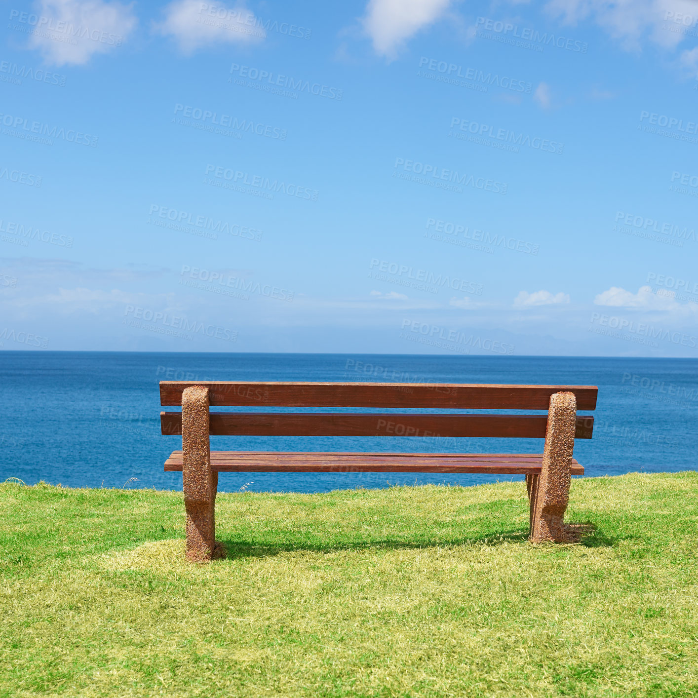 Buy stock photo Empty bench overlooking the ocean on a sunny day with copyspace. Wooden seat to sit and reflect, with therapeutic views of patterns in waves and harmony. A peaceful place to have quiet thinking time 