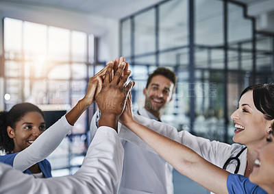 Buy stock photo Shot of a group of doctors joining their hands in solidarity at a hospital