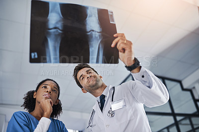 Buy stock photo Shot of two doctors discussing the results of an X-ray in a hospital