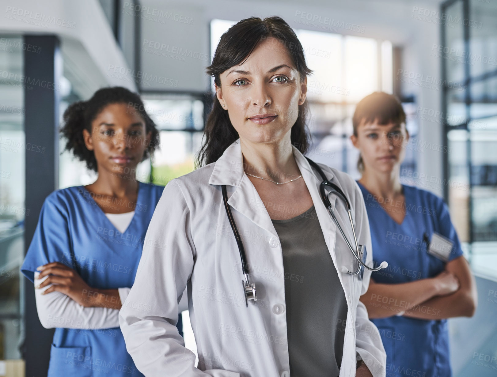 Buy stock photo Portrait of a team of confident doctors standing together in a hospital