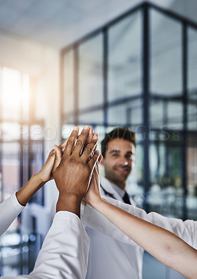 Buy stock photo Shot of a group of doctors joining their hands in solidarity at a hospital