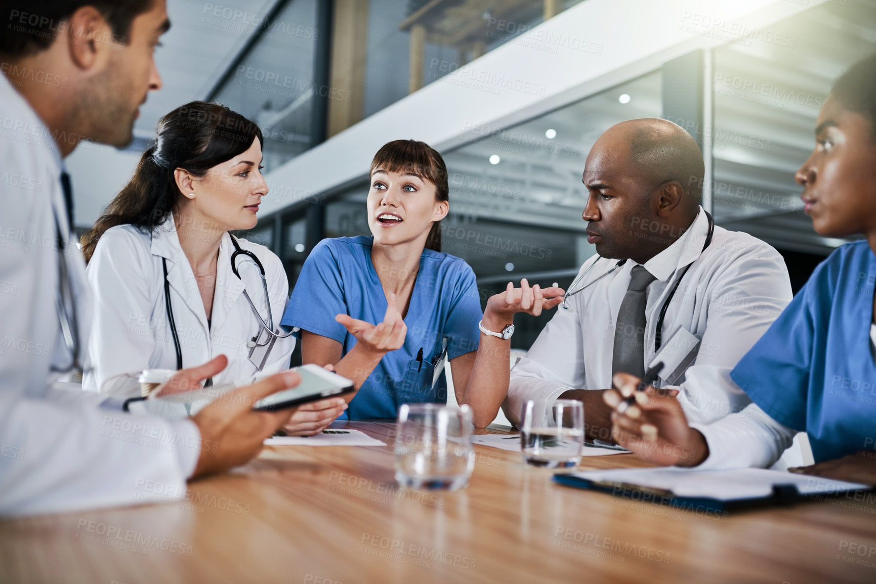 Buy stock photo Shot of a group of doctors having a meeting in a hospital